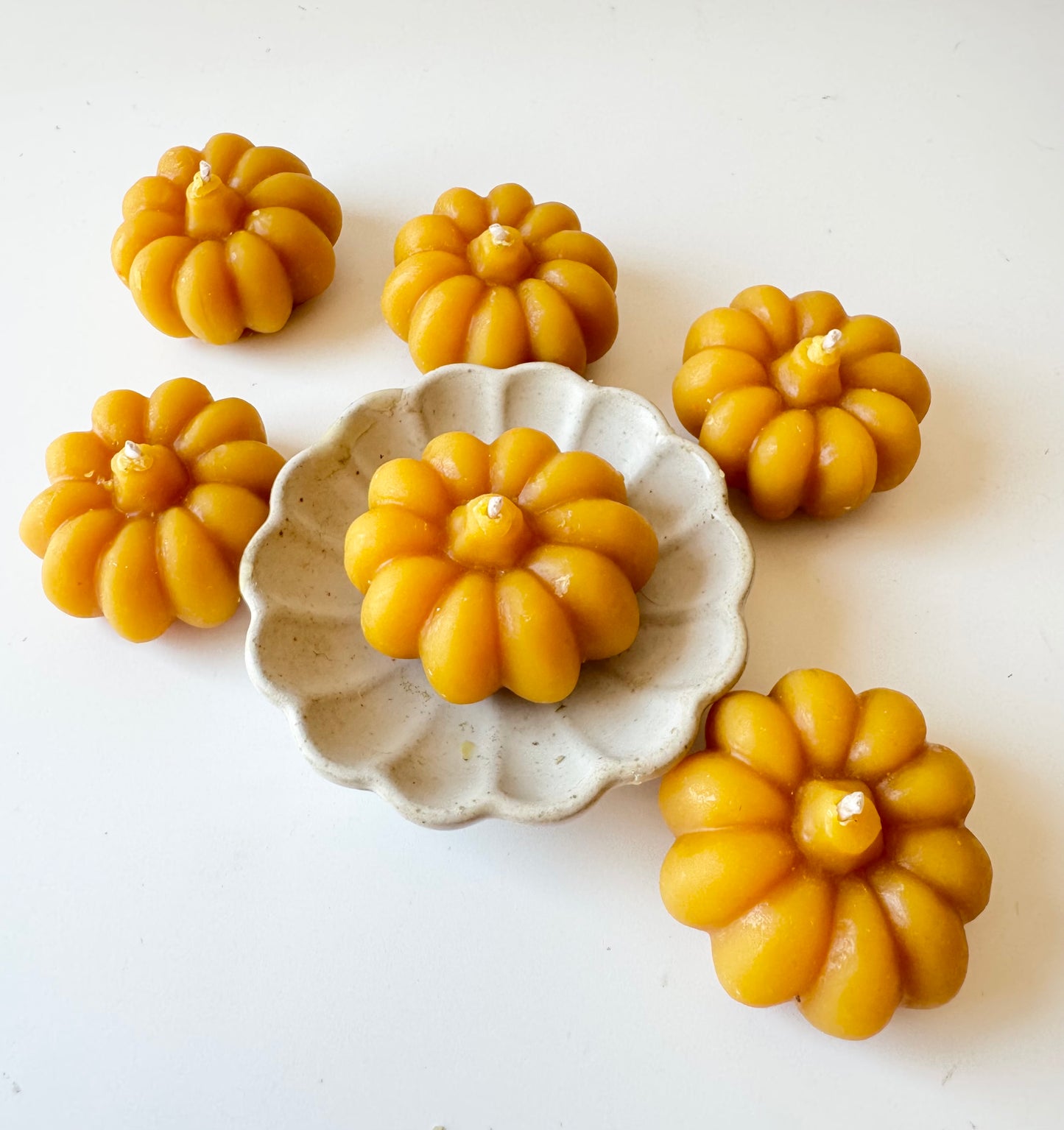 serenibee beeswax yellow pumpkin tea light candles on white trivet 