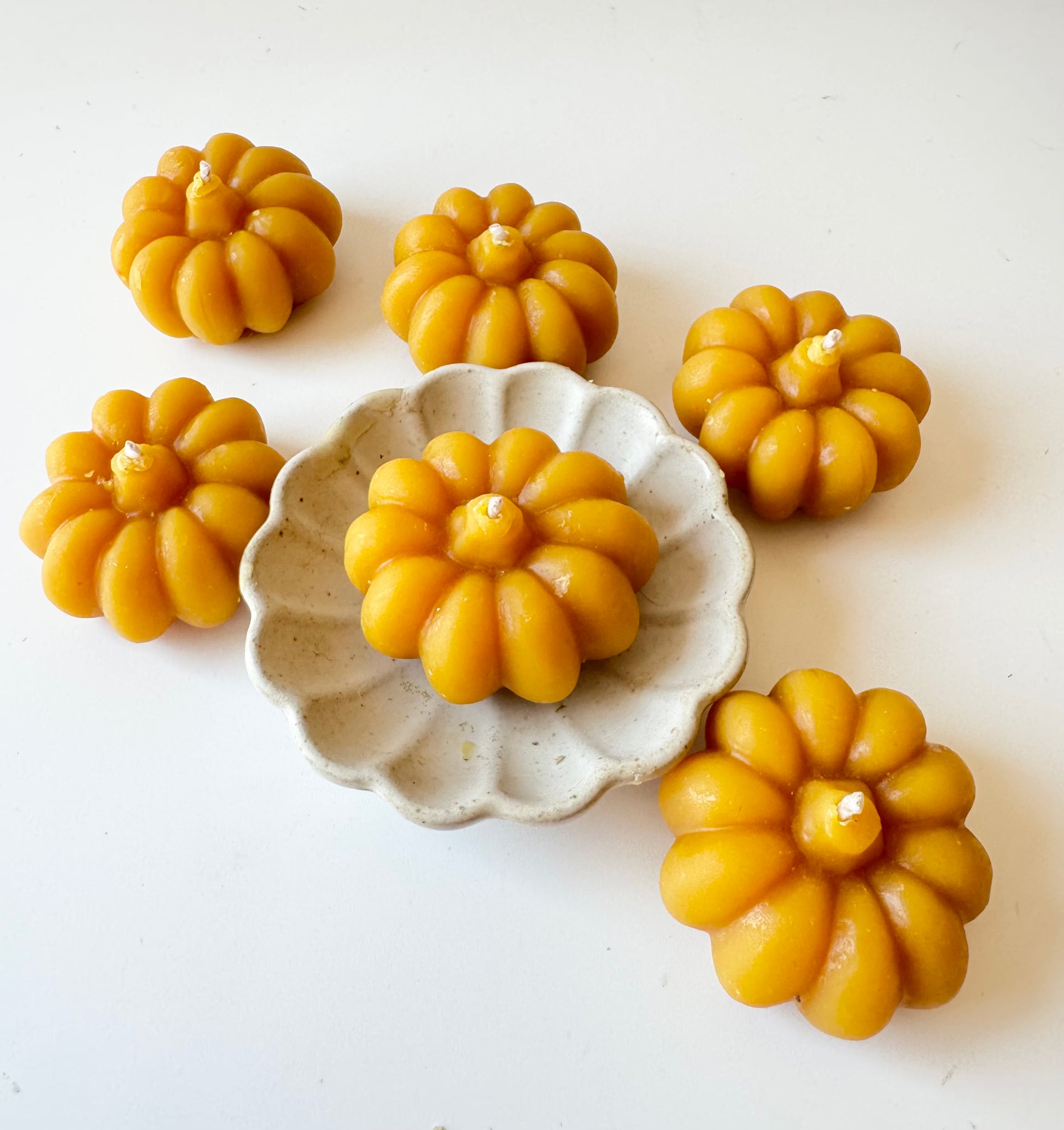 serenibee beeswax yellow pumpkin tea light candles on white trivet 